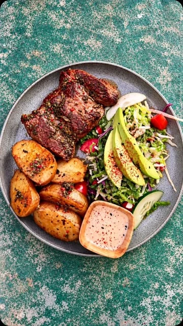 Carne a la parrilla con papas doradas y ensalada, de Clandestino
